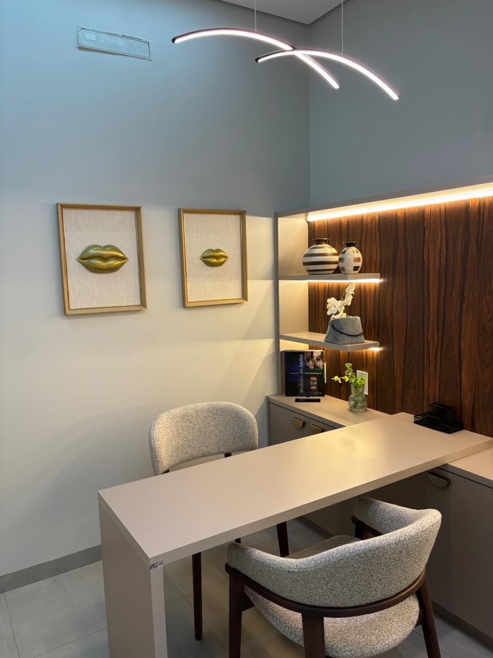 Consultório odontológico com bancada, cadeiras e iluminação decorativa