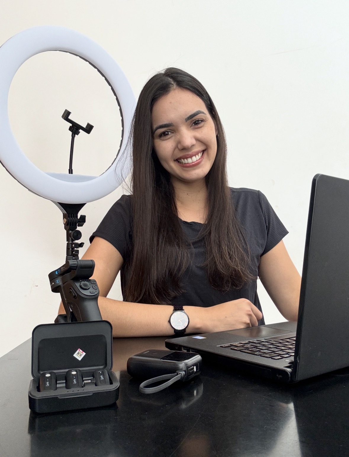 Kimberly Brito sorrindo em seu ambiente de trabalho